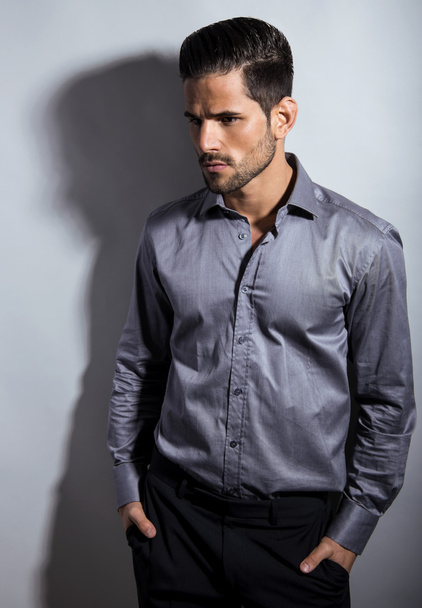 schöner junger Mann im Anzug auf grauem Hintergrund - Foto, Bild