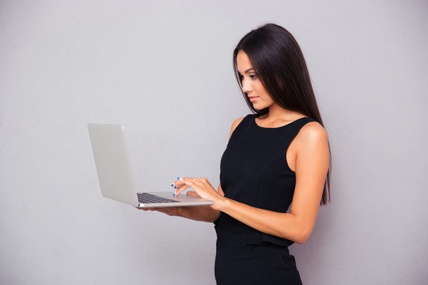 Portrait of a beautiful businesswoman using laptop  - 写真・画像