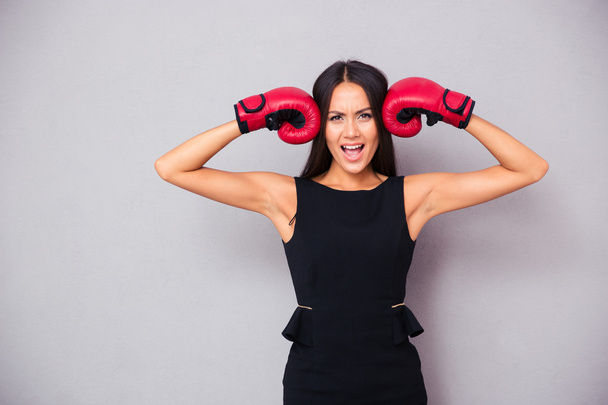 Beautiful businesswoman standing in boxing gloves - Foto, Imagem