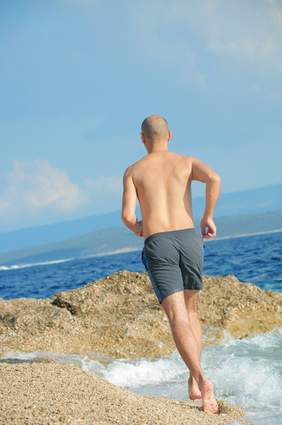 Young man running jogging on beach - Φωτογραφία, εικόνα