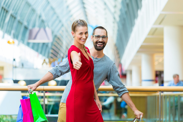Άνδρα και γυναίκας σε εμπορικό κέντρο με τσάντες - Φωτογραφία, εικόνα