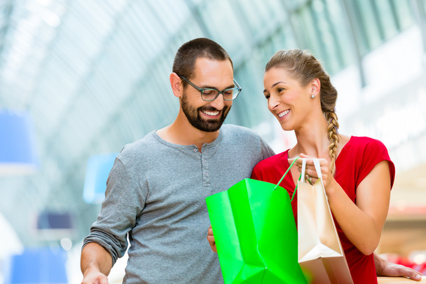 Hombre y mujer en centro comercial con bolsas
 - Foto, Imagen