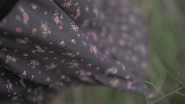 dark dress with floral print blowing by wind dressed by beautiful woman close up shot green background ungraded flat color - Footage, Video