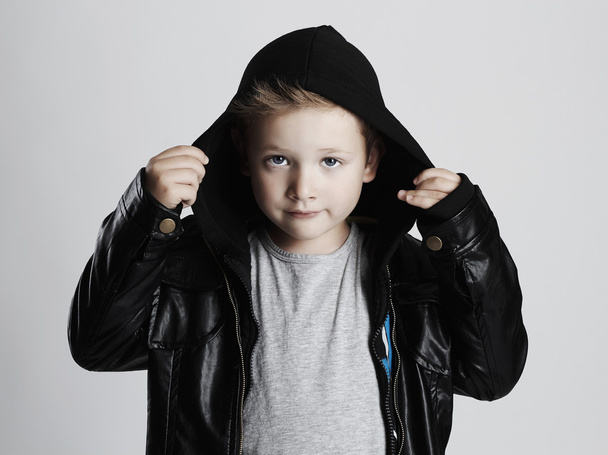 Модна дитина в шкіряному пальто. стильний красивий маленький хлопчик в капюшоні
 - Фото, зображення
