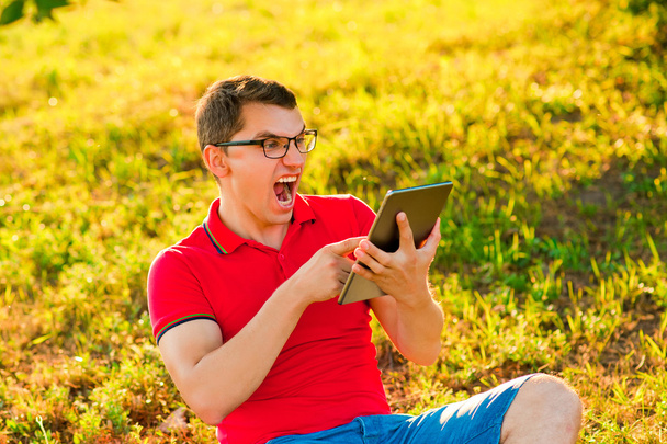 Молодой человек смотрит видео на планшете ПК
 - Фото, изображение