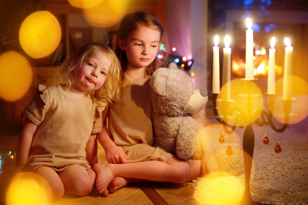 chicas sentadas junto a la chimenea en Nochebuena
 - Foto, imagen