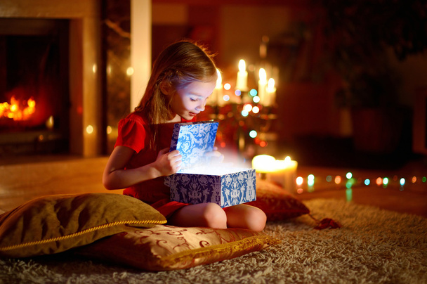 girl opening a magical Christmas gift - Zdjęcie, obraz