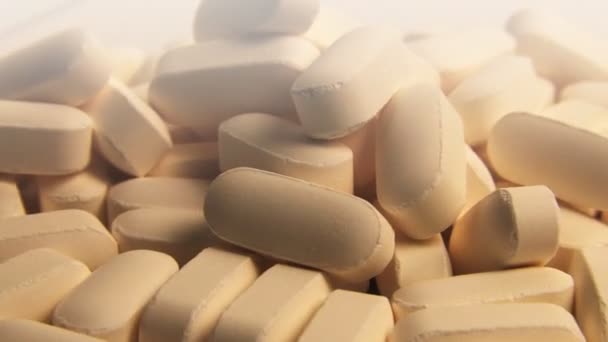 Comprimidos de vitamina que giram no branco
 - Filmagem, Vídeo