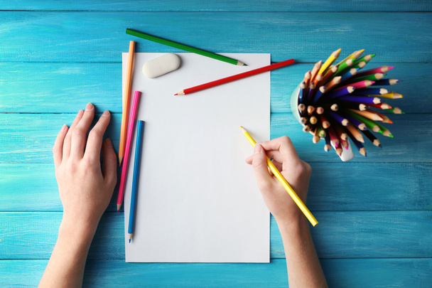 Mão com lápis de cor e folha em branco
 - Foto, Imagem