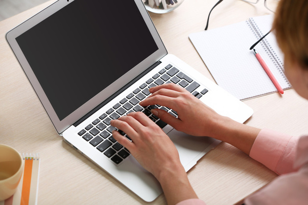Woman using laptop on workplace close up - Photo, Image