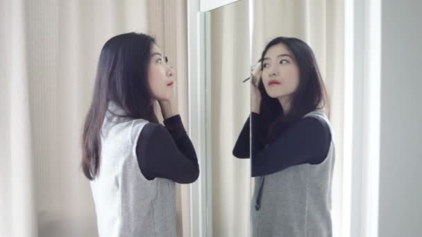 Retrato asiático hermosa mujer haciendo o aplicando maquillaje con cepillo en la ceja
 - Imágenes, Vídeo