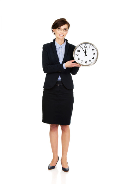 Businesswoman holding clock in hands. - Φωτογραφία, εικόνα