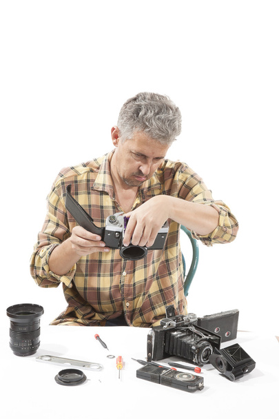 Чоловік перевіряє старовинну камеру
 - Фото, зображення