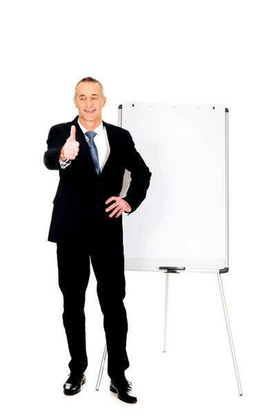 Male executive with ok sign near flip chart - Photo, image