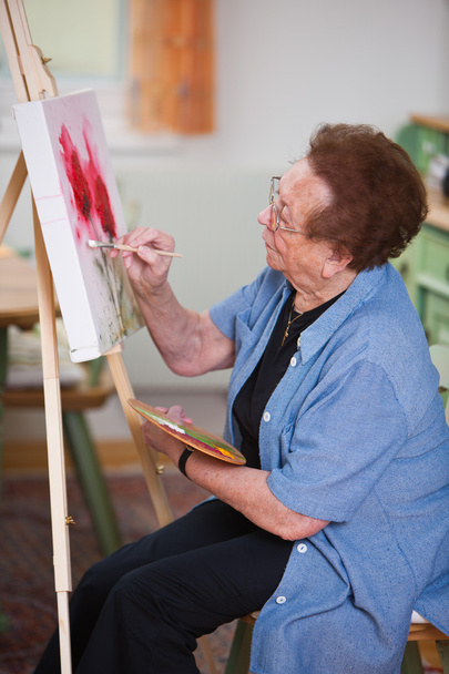 Elderly woman active in leisure time painting a picture - Fotoğraf, Görsel