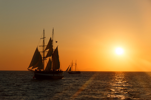 Purjelaiva siluetti auringonlaskussa merellä
 - Valokuva, kuva