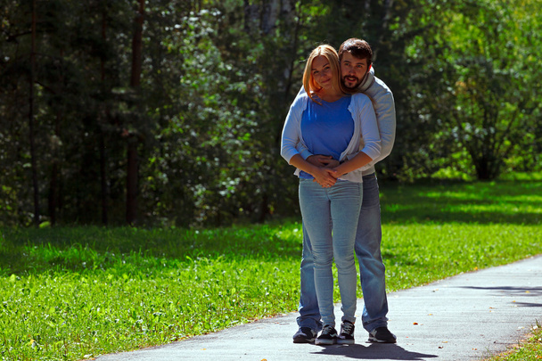 Young couple walks on sidewalk in forest - Zdjęcie, obraz