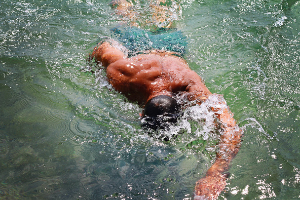 Silne muskularny mężczyzna pływanie w morzu oceanu srawl stylu. Aktywne wakacje wakacje. Pojęcie sportu, zdrowy styl życia - Zdjęcie, obraz