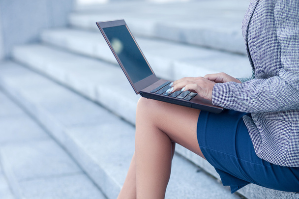 Professional young female worker is using a laptop - Fotó, kép