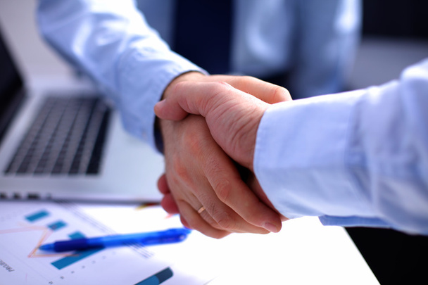 Деловое рукопожатие. Два бизнесмена пожимают друг другу руки в офисе
 - Фото, изображение