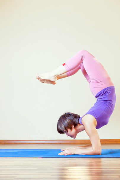 Aziatische vrouw doen oefening van de yoga bij mat - Foto, afbeelding