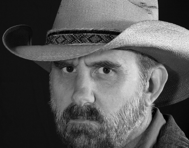 ein Cowboy mit einem strengen Stirnrunzeln in schwarz-weiß - Foto, Bild