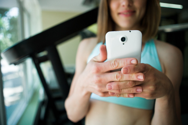 cerrar las manos de mujer con smartphone en el gimnasio
 - Foto, Imagen
