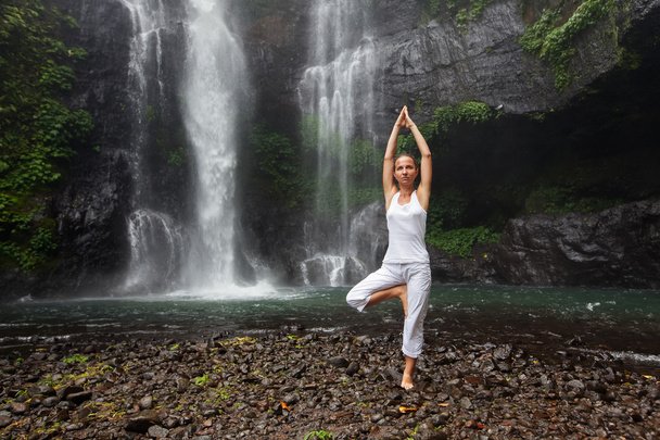 woman meditating doing yoga between waterfalls - Фото, изображение