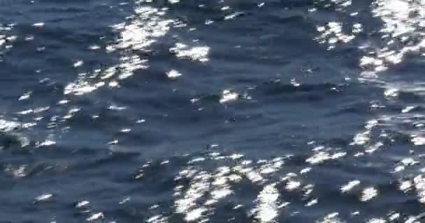 Flying over the ocean, waves forming, sparkles and wakes - Footage, Video