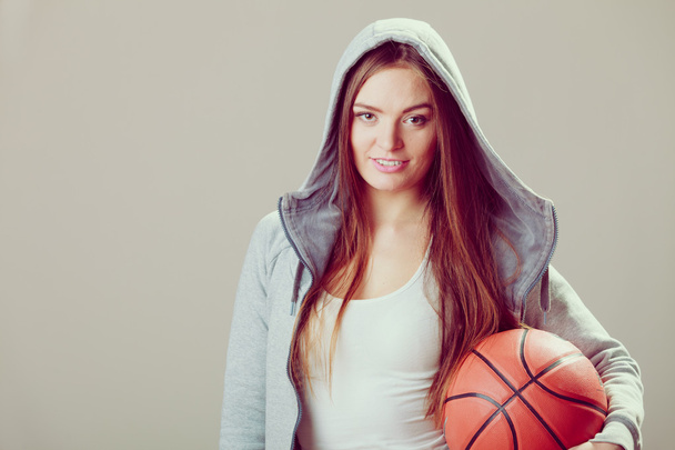 Sporty teen girl in hood holding basketball.  - Fotoğraf, Görsel