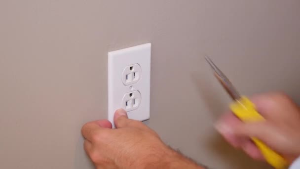 A maintenance man replaces an outlet faceplate. - Footage, Video