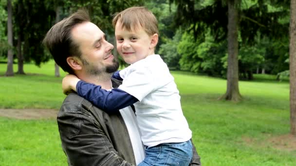 szép apa kis fia mosollyal a kamera-Park - Felvétel, videó