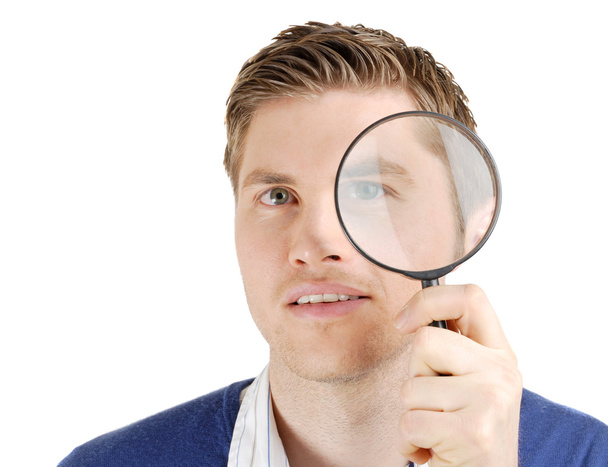 Male student looking through a magnifying glass - Photo, Image