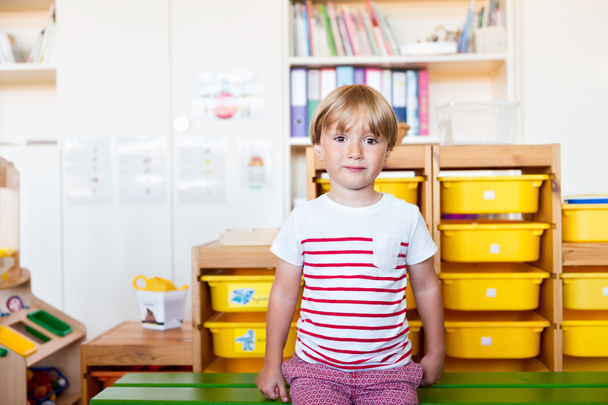 Indoor portrait of a cute little boy in a classroom - Photo, image