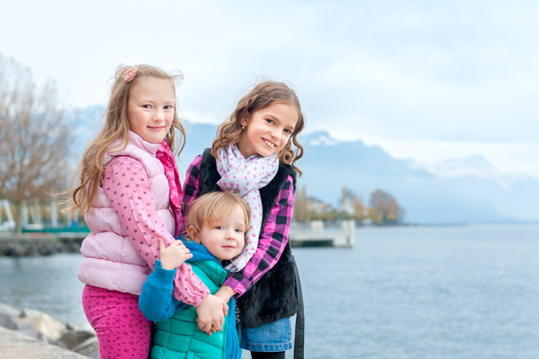 Outdoor portrait of 3 cute little girls, wearing warm coats - Zdjęcie, obraz