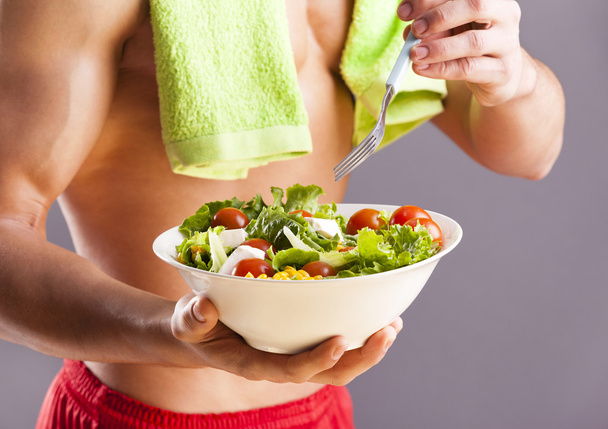 Fit man holding a bowl of fresh salad - Foto, Imagem