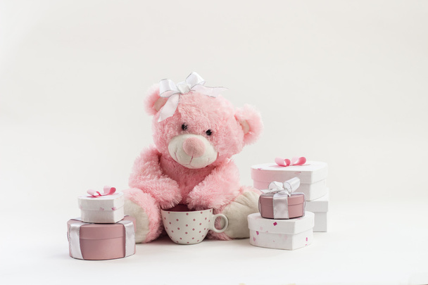 Pink teddy bear on white with presents - Foto, imagen