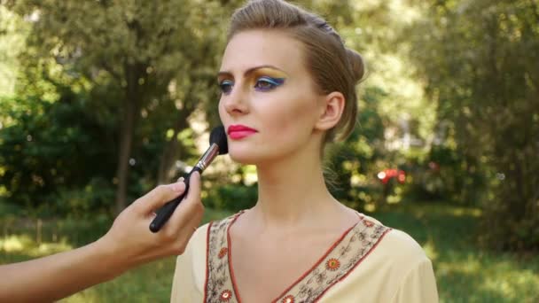 Frau zieht Gesichtspuderbürste an - Filmmaterial, Video