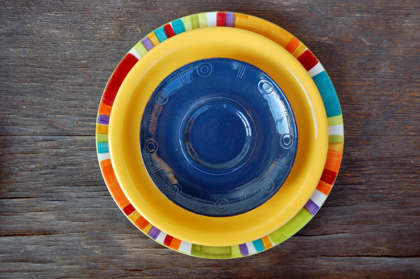 Ahşap arka plan üzerinde renkli tabaklar - Fotoğraf, Görsel