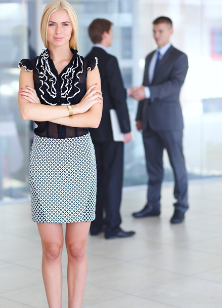Business woman standing in foreground  in office - Foto, immagini