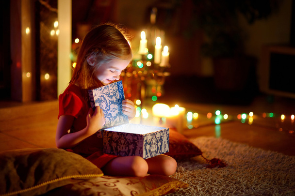 Little girl opening Christmas gift - Foto, afbeelding