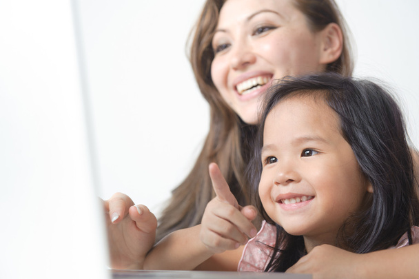 Petite fille pointant vers ordinateur portable heureux
 - Photo, image