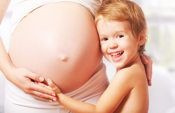 Una famiglia felice. Bambino abbraccia pancia di madre incinta
 - Foto, immagini