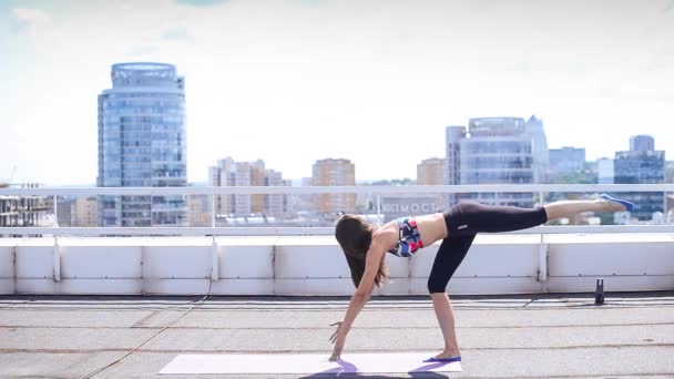 beautiful sports girl does exercises Pilates and yoga on the roof - Footage, Video