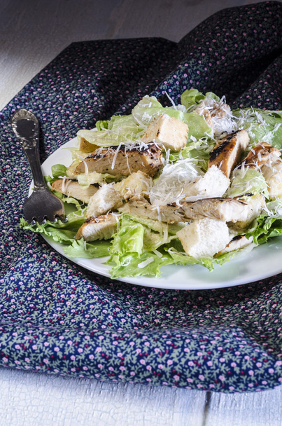 Классический куриный салат Цезарь на деревянном столе
 - Фото, изображение