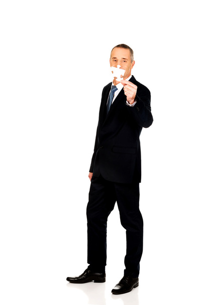 Smart businessman holding a puzzle - Фото, изображение
