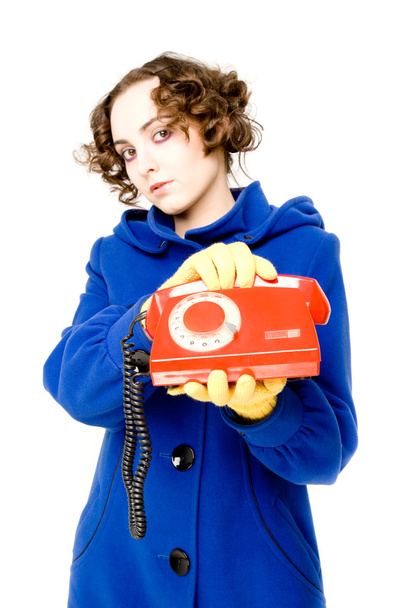 Girl with old red telephone (focus on the telephone) - Foto, afbeelding