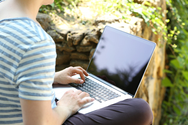 Young man with laptop outdoors - Foto, Imagen