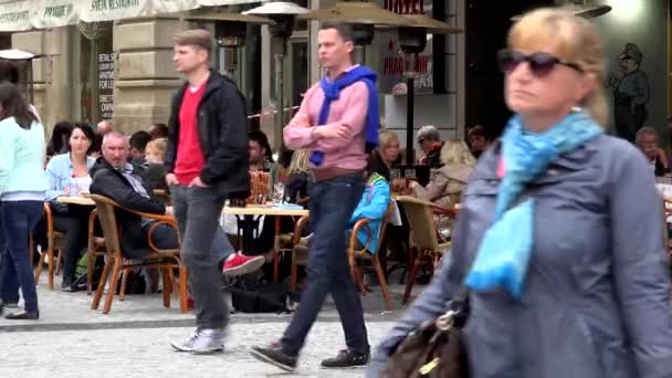 PRAGA, REPÚBLICA CHECA - 30 DE MAYO DE 2015: ciudad - calle urbana - acera con gente caminando - restaurante: asientos al aire libre con gente sentada
 - Metraje, vídeo