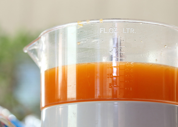 zumo de naranja fresco en la máquina de juicer con mano
 - Foto, imagen